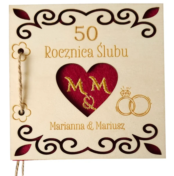 Personalizowana, drewniana karta upominkowa skrywa w środku haftowany czerwony filc, przewiązana jutowym sznurkiem, zapakowana w złotą, papierową kopertę