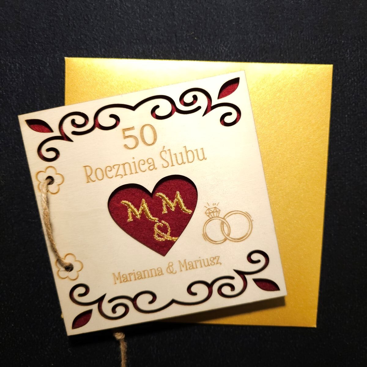 Karta grawerowana personalizowana upominek rocznica ślubu haft koperta dedykacja 5 Personalizowana, drewniana karta upominkowa skrywa w środku haftowany czerwony filc, przewiązana jutowym sznurkiem, zapakowana w złotą, papierową kopertę