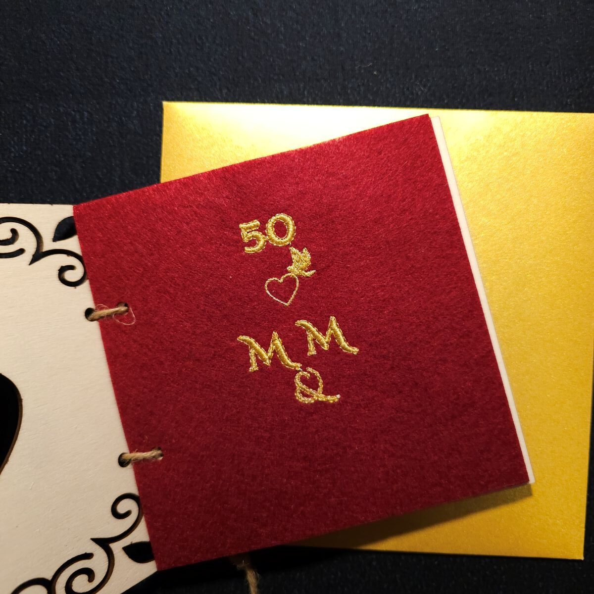 Karta grawerowana personalizowana upominek rocznica ślubu haft koperta dedykacja 6 Personalizowana, drewniana karta upominkowa skrywa w środku haftowany czerwony filc, przewiązana jutowym sznurkiem, zapakowana w złotą, papierową kopertę