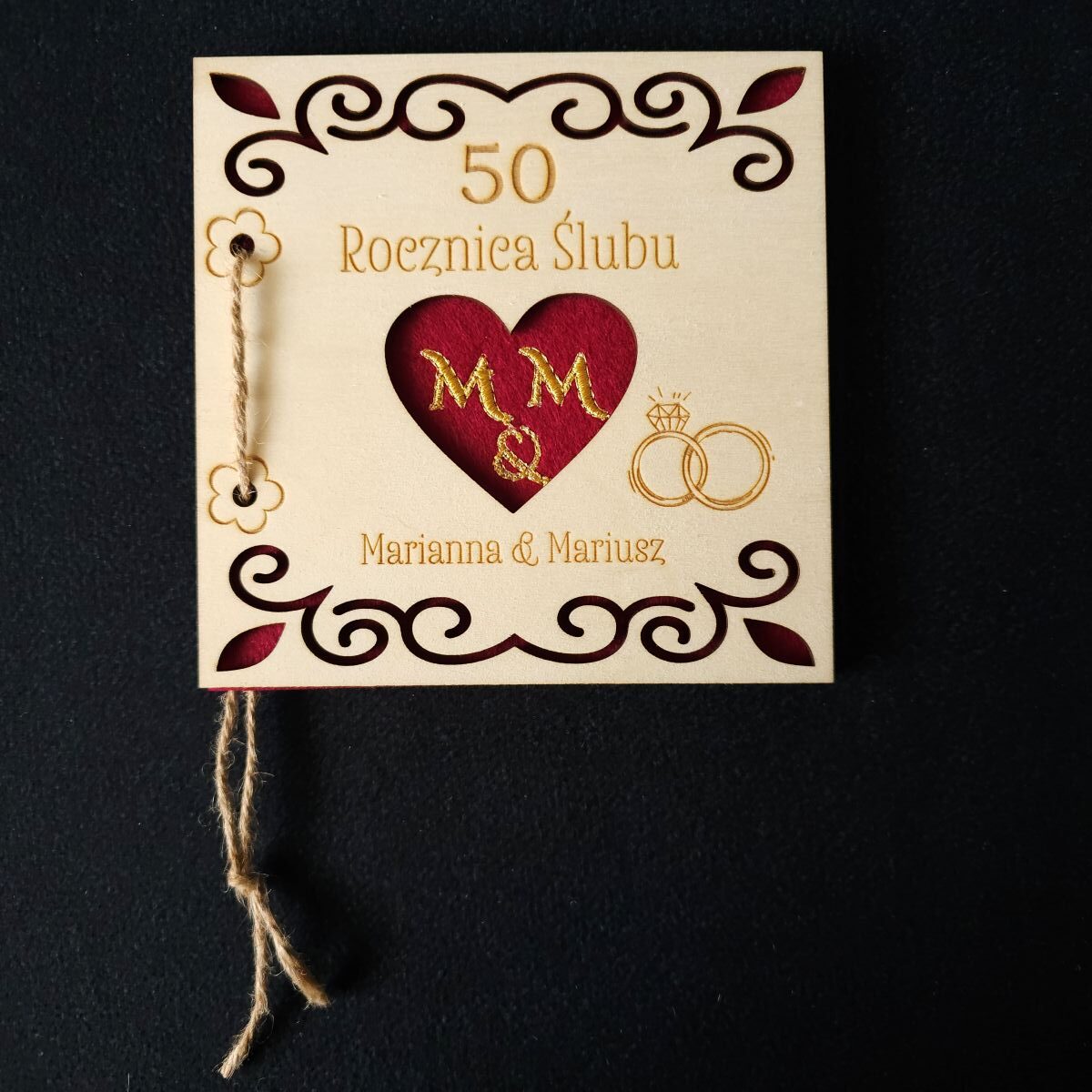 Karta grawerowana personalizowana upominek rocznica ślubu haft koperta dedykacja 9 Personalizowana, drewniana karta upominkowa skrywa w środku haftowany czerwony filc, przewiązana jutowym sznurkiem, zapakowana w złotą, papierową kopertę